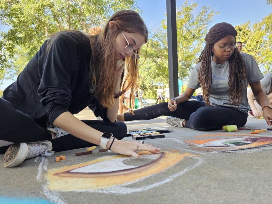 Sydney Spence and Paula Peire, 12th grade, hard at work to compleate their chalky creation.