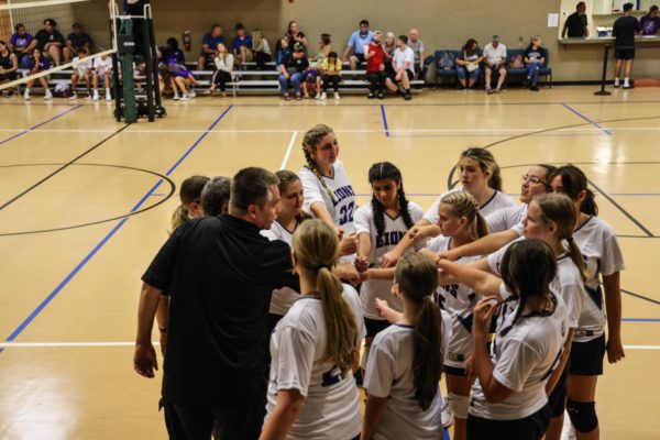 The Lions Volleyball team spend a moment together before starting their game. 