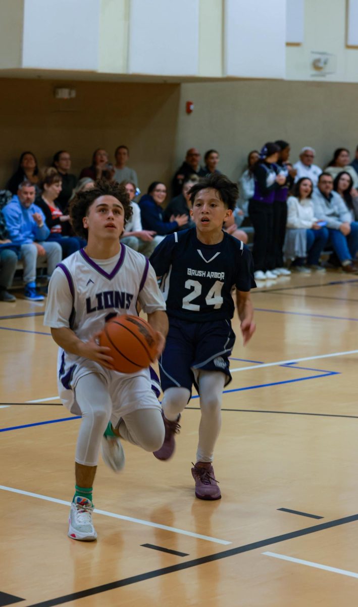 Zadiel Vientos, 11th grade, driving down the court for a layup.