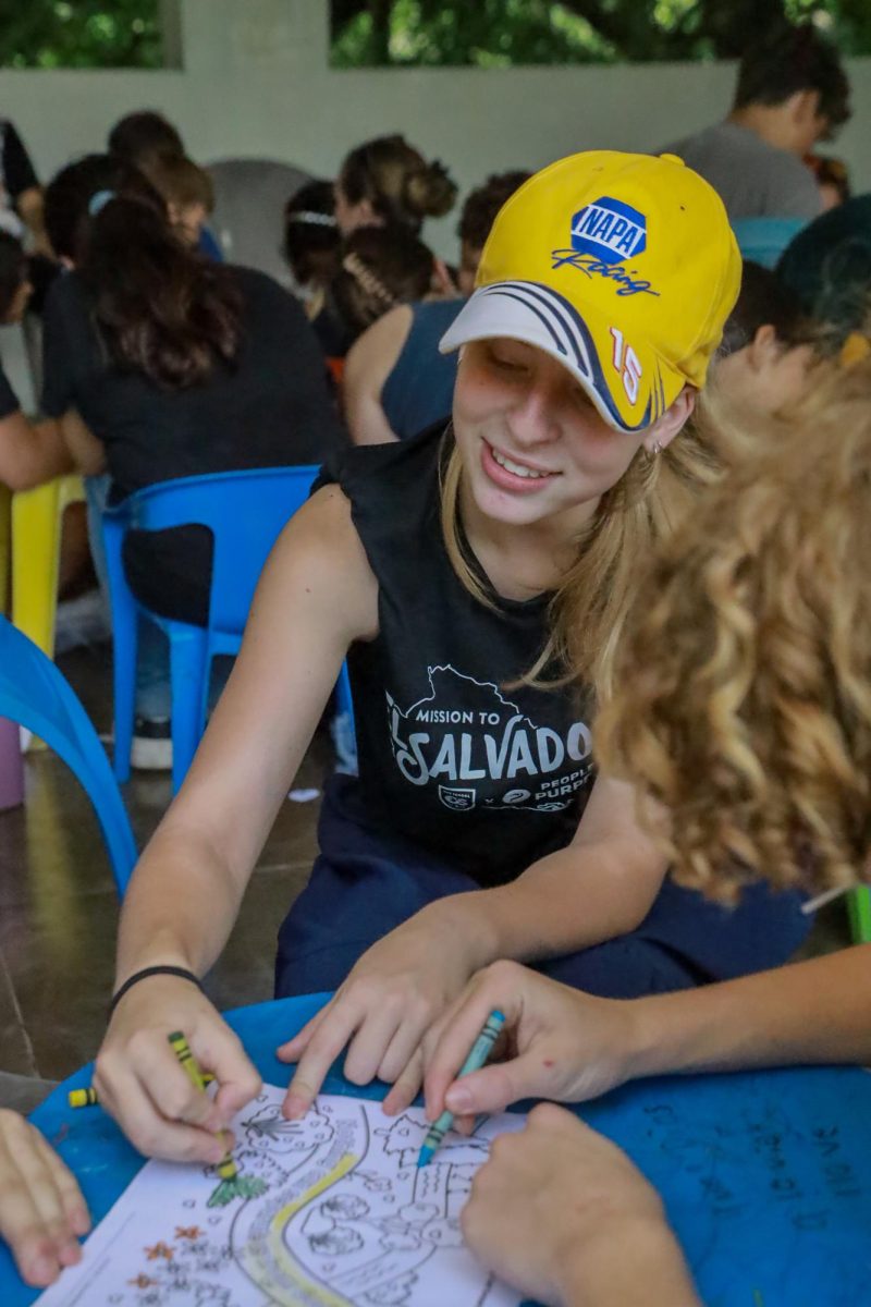 As Ava Crozier, 12th grade, colors with the children, the team preps for the service. 