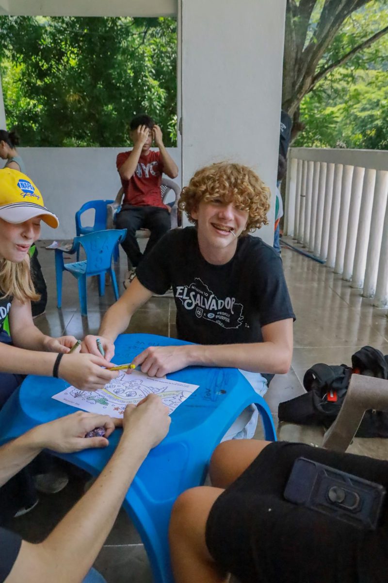 At the local church, Caden Tucker and Ava Crozier, 12th grade, connect with the children. 