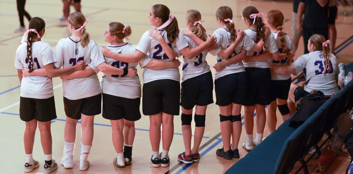 The 2025 Lions Girls Volleyball Team embraces one final time at the conclusion of their season-ending game.
