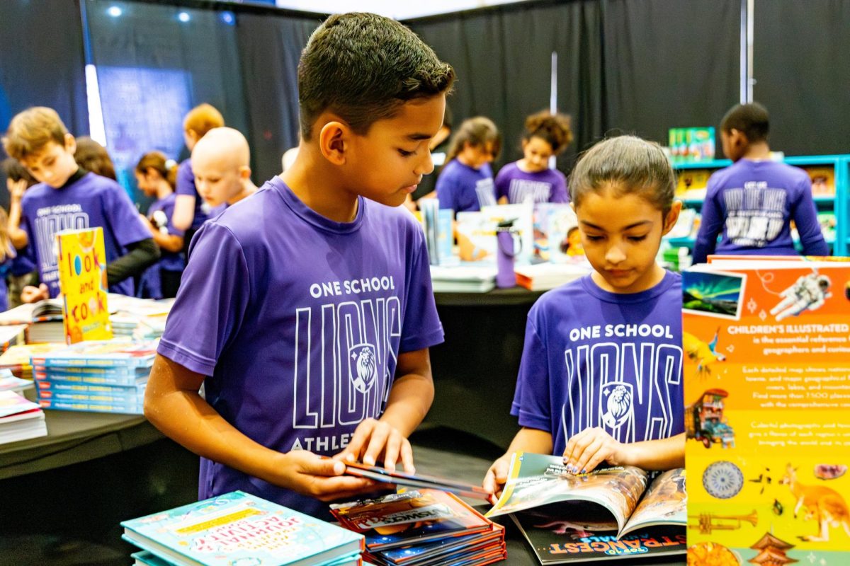 Zavian Gonzalez and Mya Zapata check out books at the book fair. 