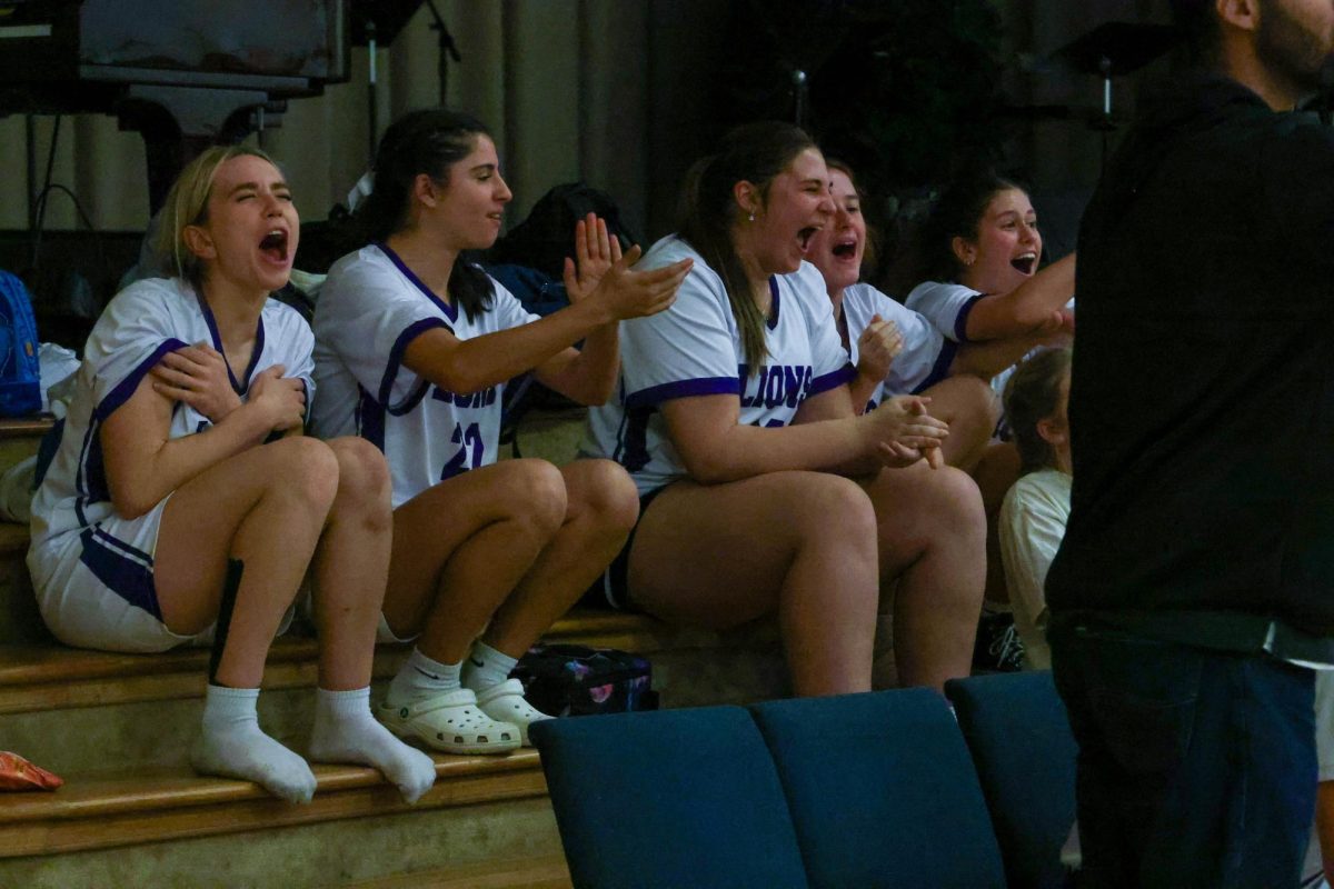 After their game, the Lady Lions cheered on the boys' varsity team. 